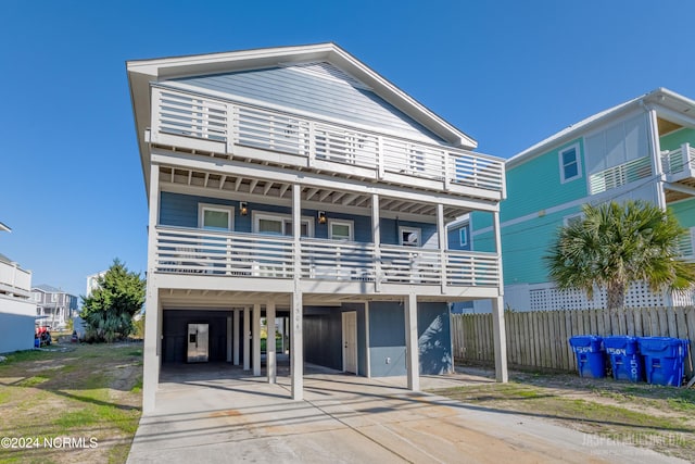 coastal home featuring a balcony and a carport