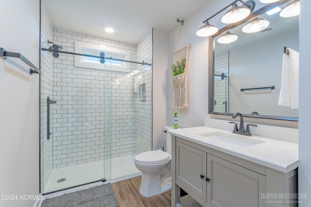 bathroom featuring vanity, toilet, hardwood / wood-style flooring, and an enclosed shower