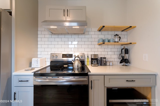 kitchen with decorative backsplash, appliances with stainless steel finishes, white cabinetry, and extractor fan