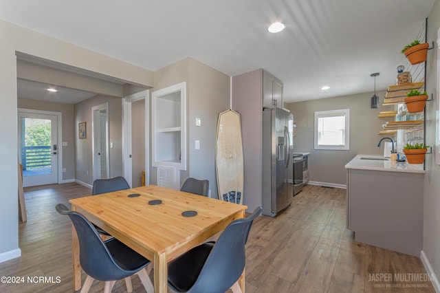 dining space featuring sink and light wood-type flooring