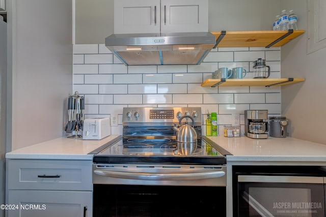 kitchen featuring white cabinetry, backsplash, stainless steel appliances, and exhaust hood