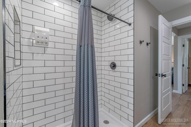 bathroom with hardwood / wood-style floors and a shower with shower curtain