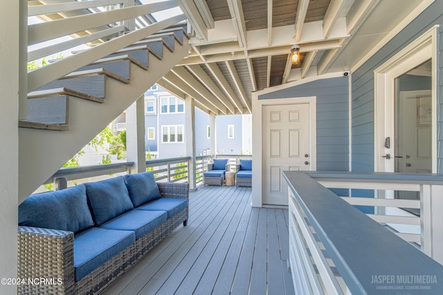 wooden terrace with an outdoor living space