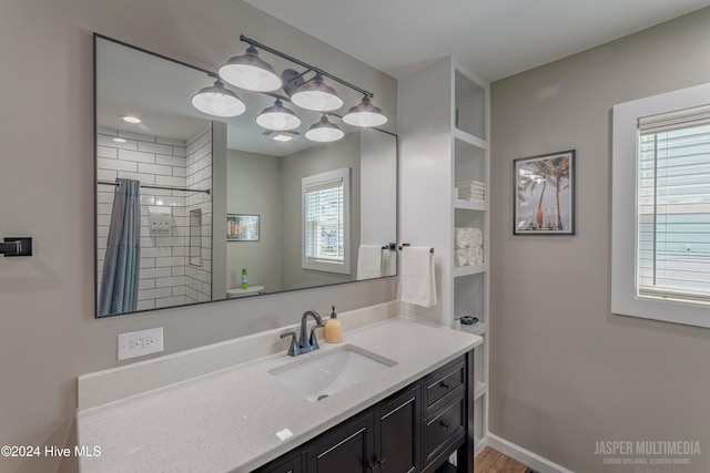 bathroom with walk in shower, vanity, wood-type flooring, and plenty of natural light