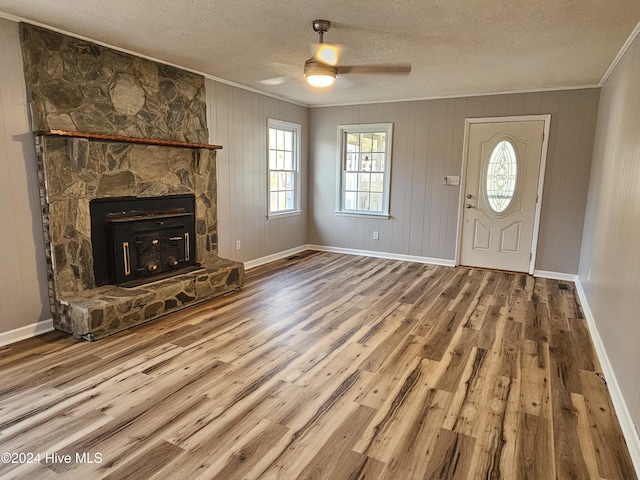 unfurnished living room with crown molding, a textured ceiling, and hardwood / wood-style flooring