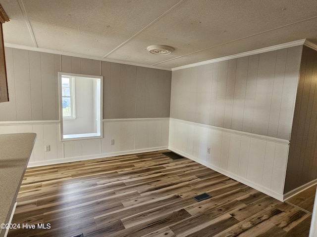 spare room with dark hardwood / wood-style flooring, crown molding, and a textured ceiling