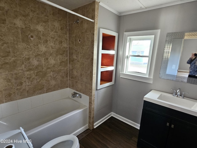 full bathroom with toilet, crown molding, vanity, tiled shower / bath combo, and hardwood / wood-style flooring