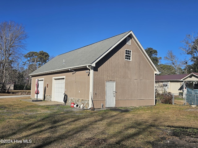 back of house featuring a garage and a yard