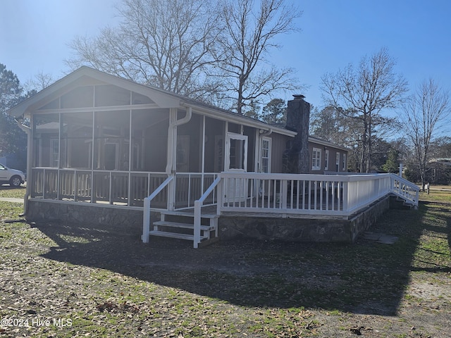 rear view of house featuring a sunroom