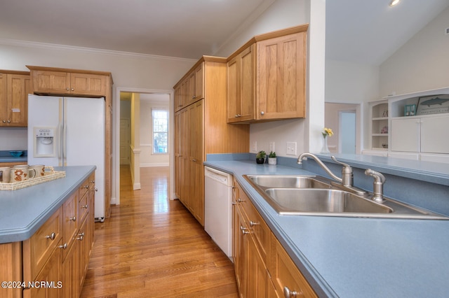 kitchen featuring white dishwasher, ornamental molding, sink, vaulted ceiling, and light hardwood / wood-style floors