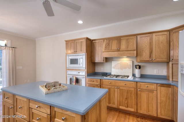 kitchen with white appliances, light hardwood / wood-style floors, crown molding, and a kitchen island