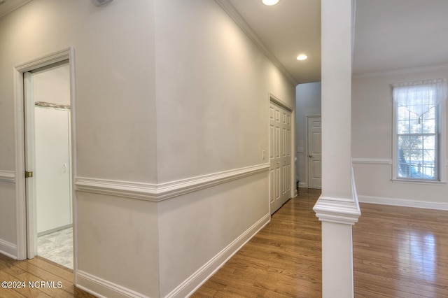 hall with ornamental molding and hardwood / wood-style floors