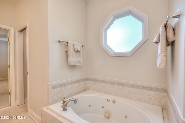 bathroom featuring a relaxing tiled tub and tile patterned flooring