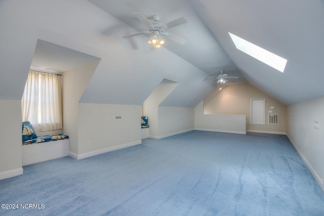 bonus room featuring light carpet, lofted ceiling with skylight, and ceiling fan