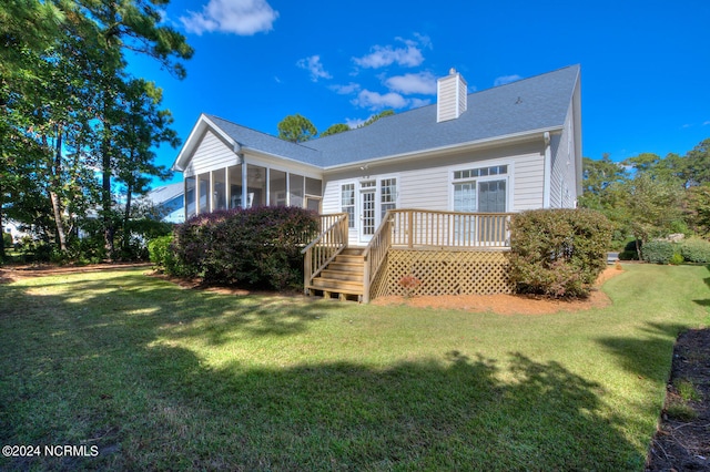 back of property featuring a yard, a sunroom, and a wooden deck