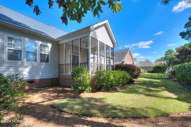 view of side of home with a lawn and a sunroom