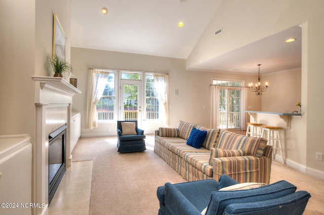 carpeted living room featuring a chandelier, high vaulted ceiling, and plenty of natural light