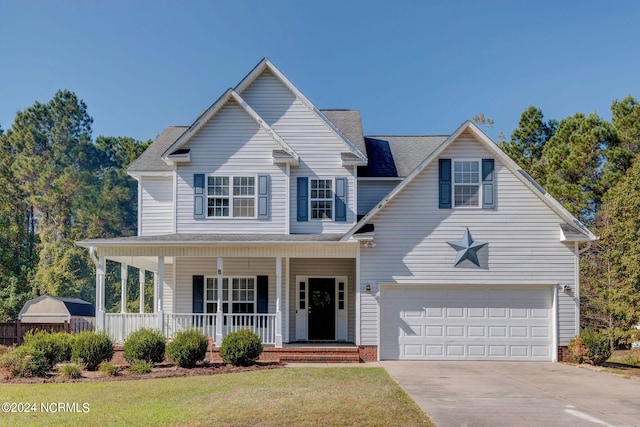 front of property featuring covered porch, a garage, and a front lawn