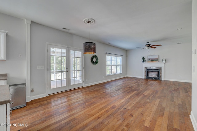 unfurnished living room with french doors, ceiling fan, and hardwood / wood-style floors