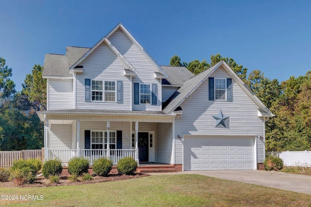 view of property with covered porch, a front lawn, and a garage