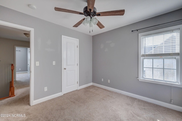 unfurnished bedroom featuring light colored carpet and ceiling fan