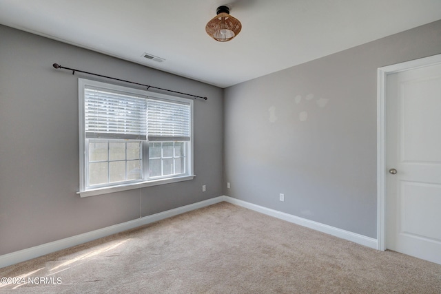 spare room featuring light colored carpet