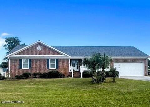 ranch-style home with a garage and a front yard