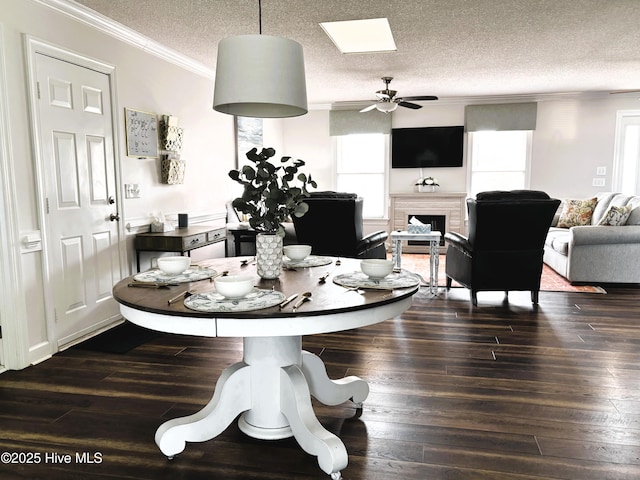 117 Buds Ln, Cedar Point, NC 28584 - dining room featuring ornamental molding, a ceiling fan, a textured ceiling, a fireplace, and dark wood finished floors