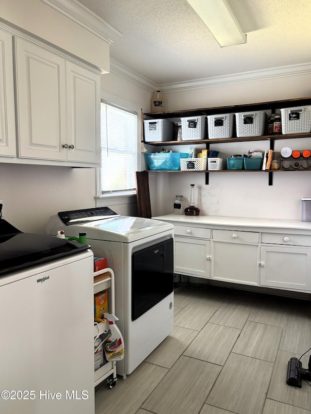 117 Buds Ln, Cedar Point, NC 28584 - laundry room with washing machine and clothes dryer, cabinet space, crown molding, wood tiled floors, and a textured ceiling