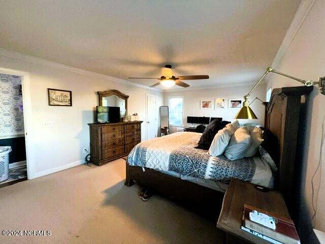 bedroom featuring ceiling fan, light carpet, and ornamental molding