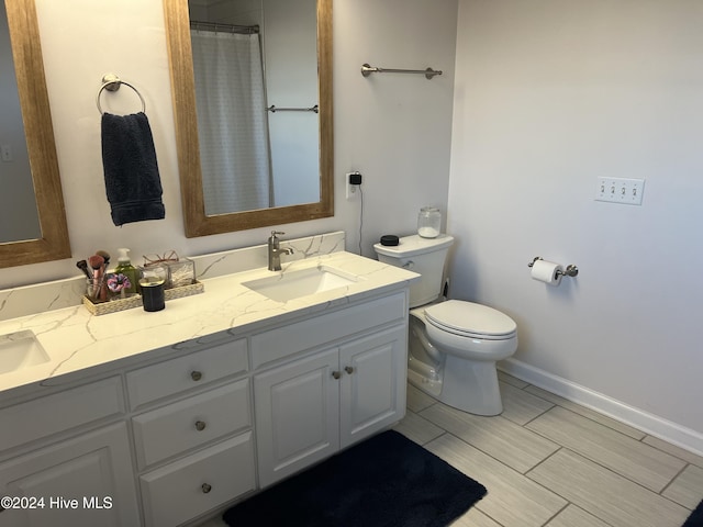 bathroom featuring vanity, a shower with shower curtain, and toilet