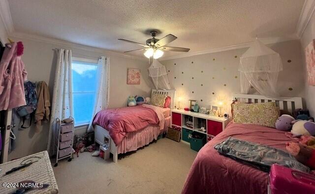 bedroom featuring carpet, ceiling fan, ornamental molding, and a textured ceiling