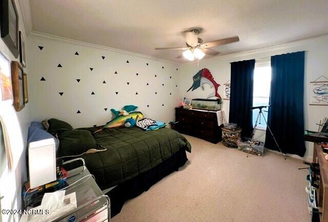 carpeted bedroom with ceiling fan and crown molding