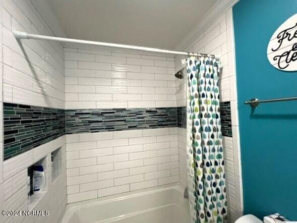 bathroom featuring toilet and shower / tub combo with curtain