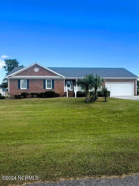 ranch-style home with a garage and a front lawn