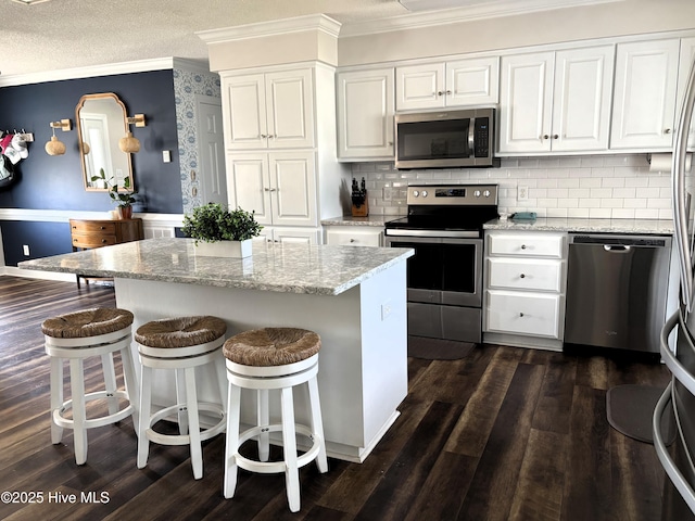 117 Buds Ln, Cedar Point, NC 28584 - kitchen featuring appliances with stainless steel finishes, crown molding, white cabinets, and dark wood-style floors