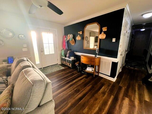 living room featuring dark hardwood / wood-style floors, ceiling fan, and ornamental molding