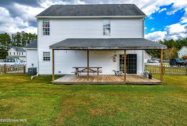 back of house featuring a deck, a lawn, and central AC