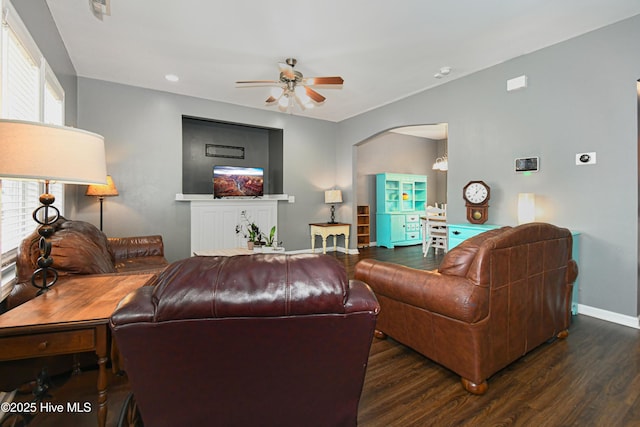 living room featuring ceiling fan and dark wood-type flooring