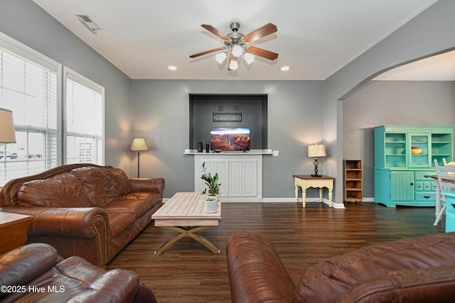 living room with ceiling fan and dark wood-type flooring