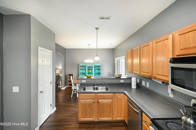 kitchen featuring dark hardwood / wood-style flooring, stainless steel appliances, sink, hanging light fixtures, and kitchen peninsula