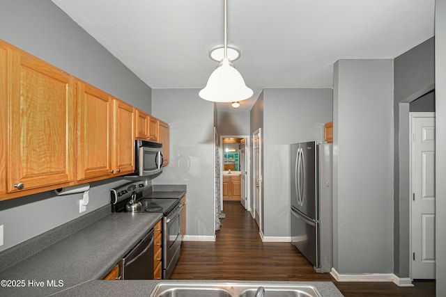 kitchen featuring decorative light fixtures, dark hardwood / wood-style flooring, and appliances with stainless steel finishes