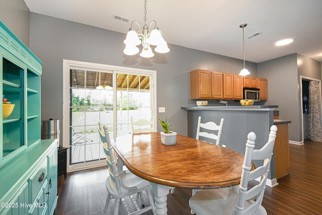 dining space featuring dark wood-type flooring and a notable chandelier