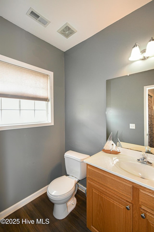 bathroom with vanity, toilet, and hardwood / wood-style flooring