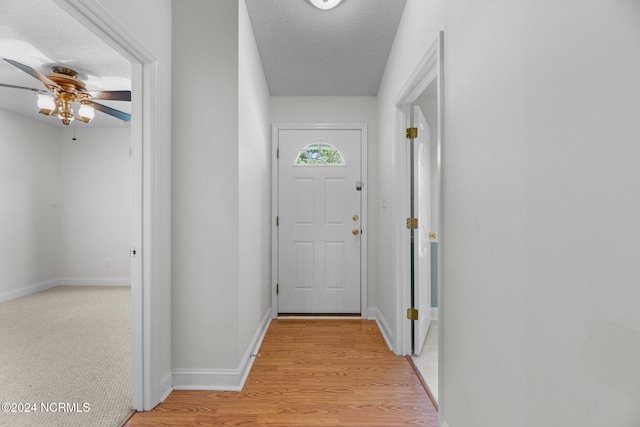 entryway with light hardwood / wood-style floors, a textured ceiling, and ceiling fan