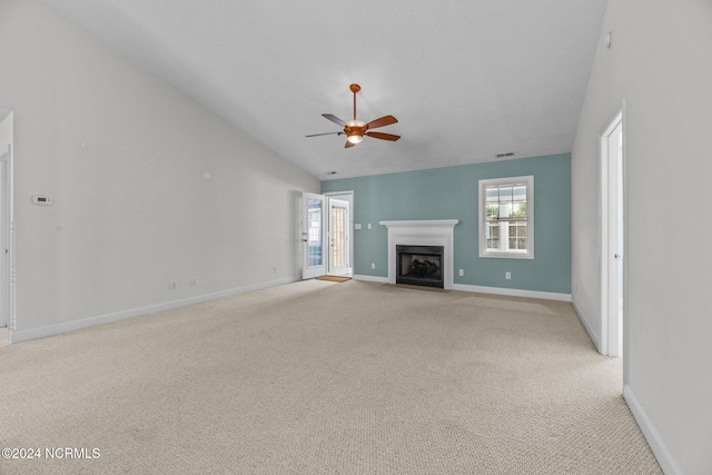 unfurnished living room with vaulted ceiling, light colored carpet, and ceiling fan