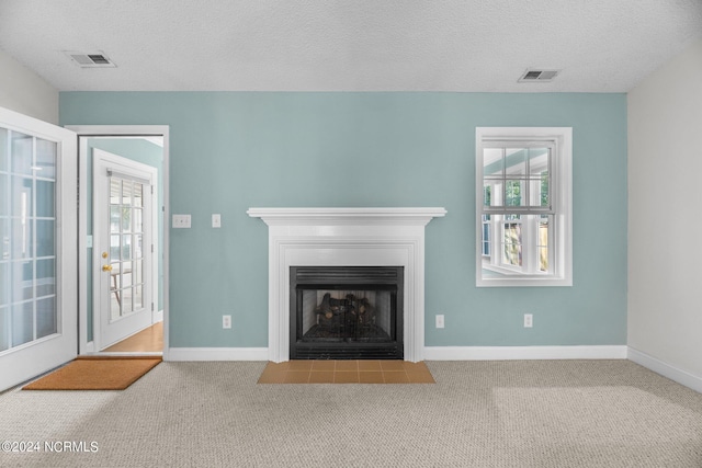 unfurnished living room featuring a textured ceiling and carpet