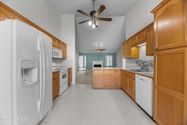 kitchen featuring white appliances, sink, kitchen peninsula, ceiling fan, and high vaulted ceiling