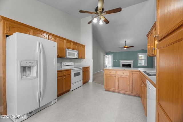 kitchen featuring kitchen peninsula, ceiling fan, vaulted ceiling, sink, and white appliances