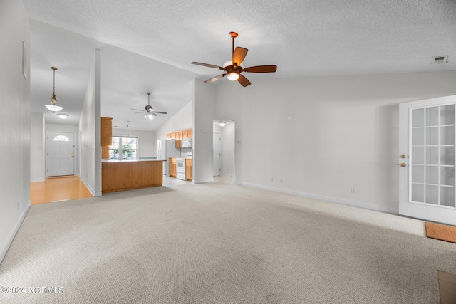 unfurnished living room featuring lofted ceiling, a textured ceiling, light colored carpet, and ceiling fan